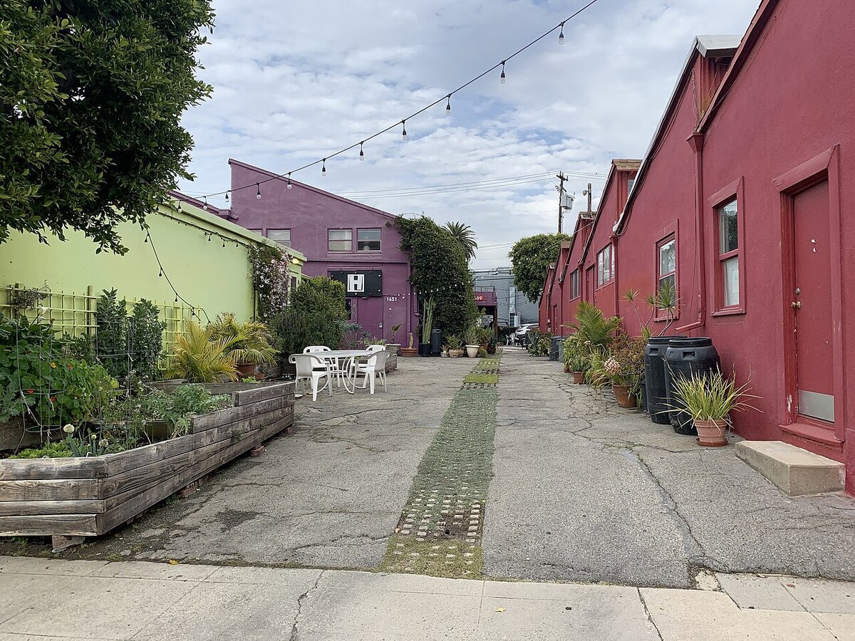 Colorful artist studio buildings and a shared courtyard with string lights and planter boxes at 18th Street Arts Center in Santa Monica