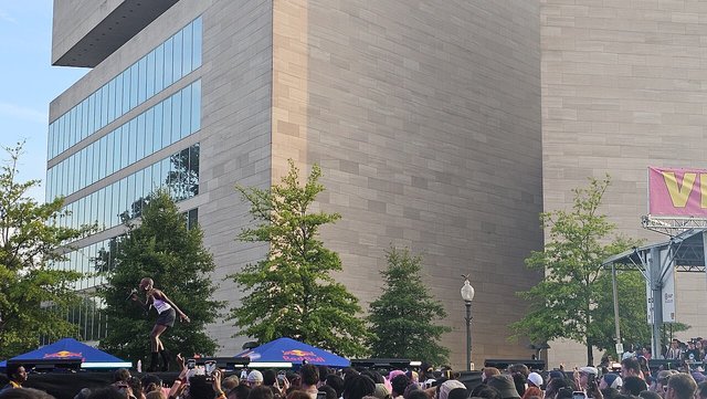 Cynthia Erivo singing into a microphone on an outdoor stage