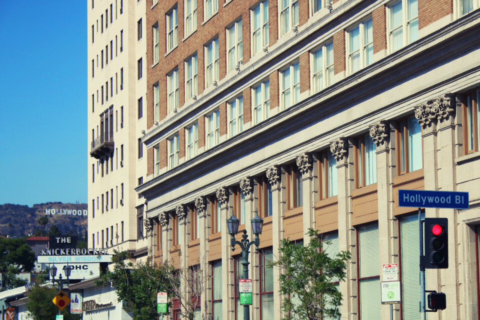 Hollywood Boulevard street corner with a brick office building, street lamps and a Hollywood Blvd sign