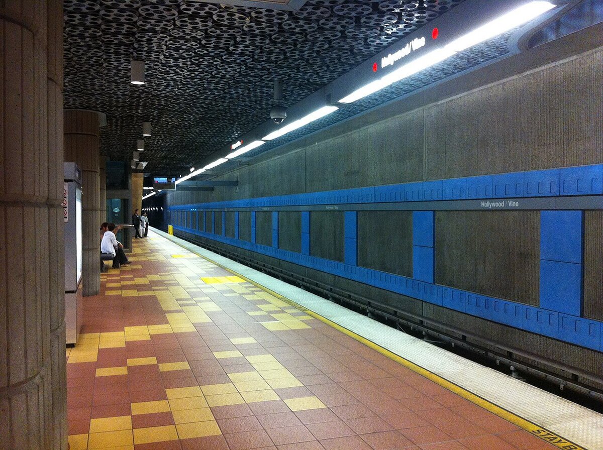 Hollywood/Vine Metro station platform with a film-reel ceiling and blue wall panels.