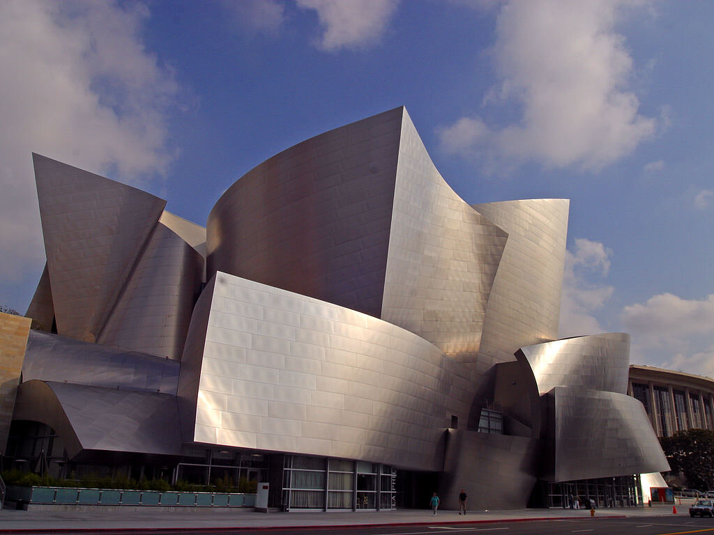 Stainless steel curves of Walt Disney Concert Hall under a blue sky with clouds