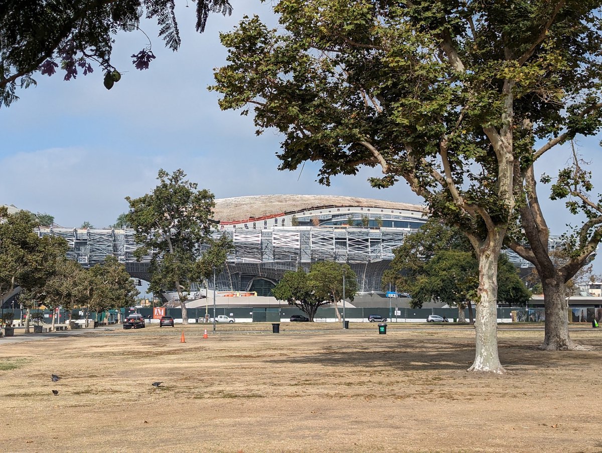Lucas Museum of Narrative Art building exterior under construction in Exposition Park, Los Angeles, showing its distinctive cloud-like curved FRP facade