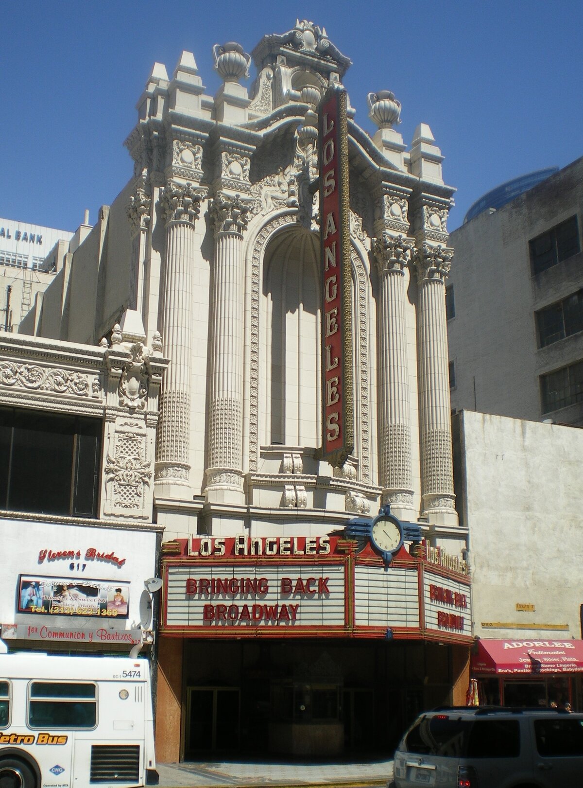 Cream terracotta facade and red vertical sign of the Los Angeles Theatre on Broadway