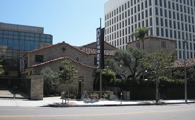 Brick and tile-roofed Geffen Playhouse building with a Geffen banner on a Westwood street corner