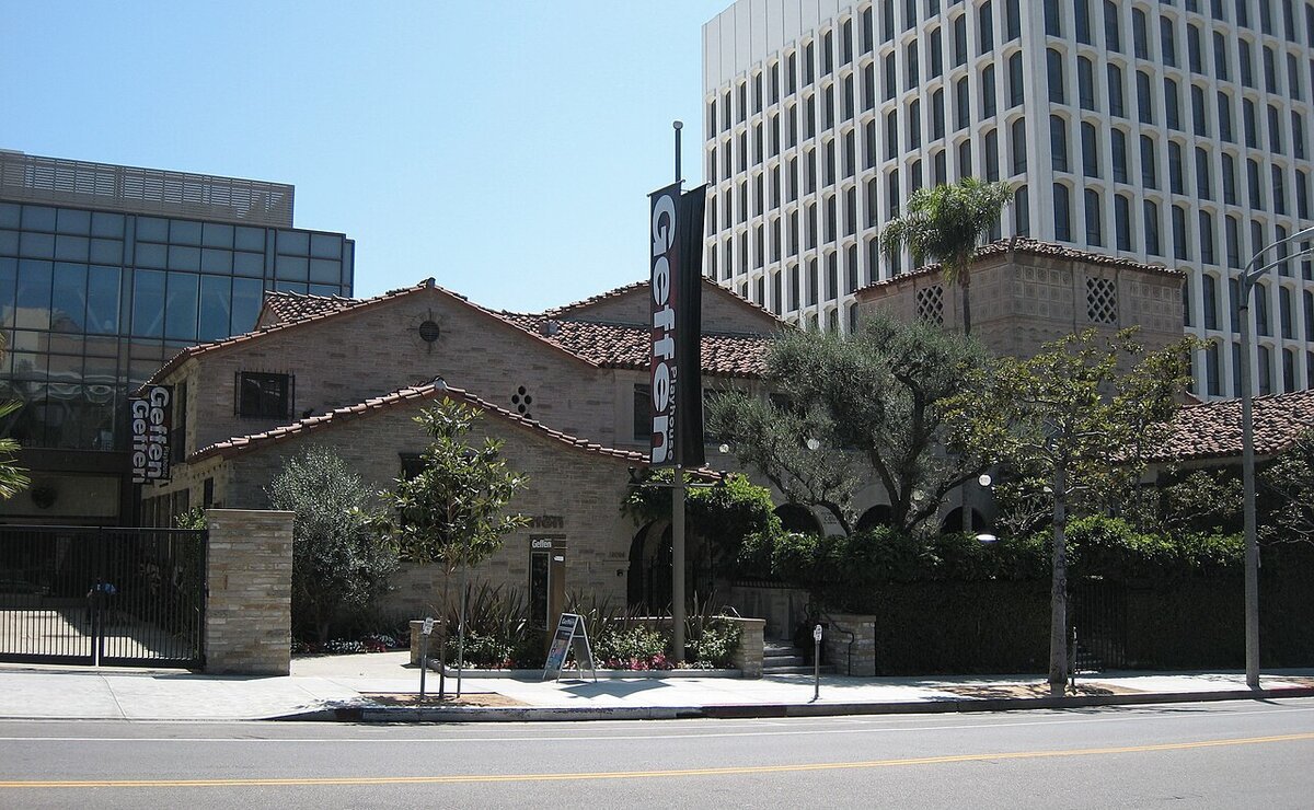 Brick and tile-roofed Geffen Playhouse building with a Geffen banner on a Westwood street corner