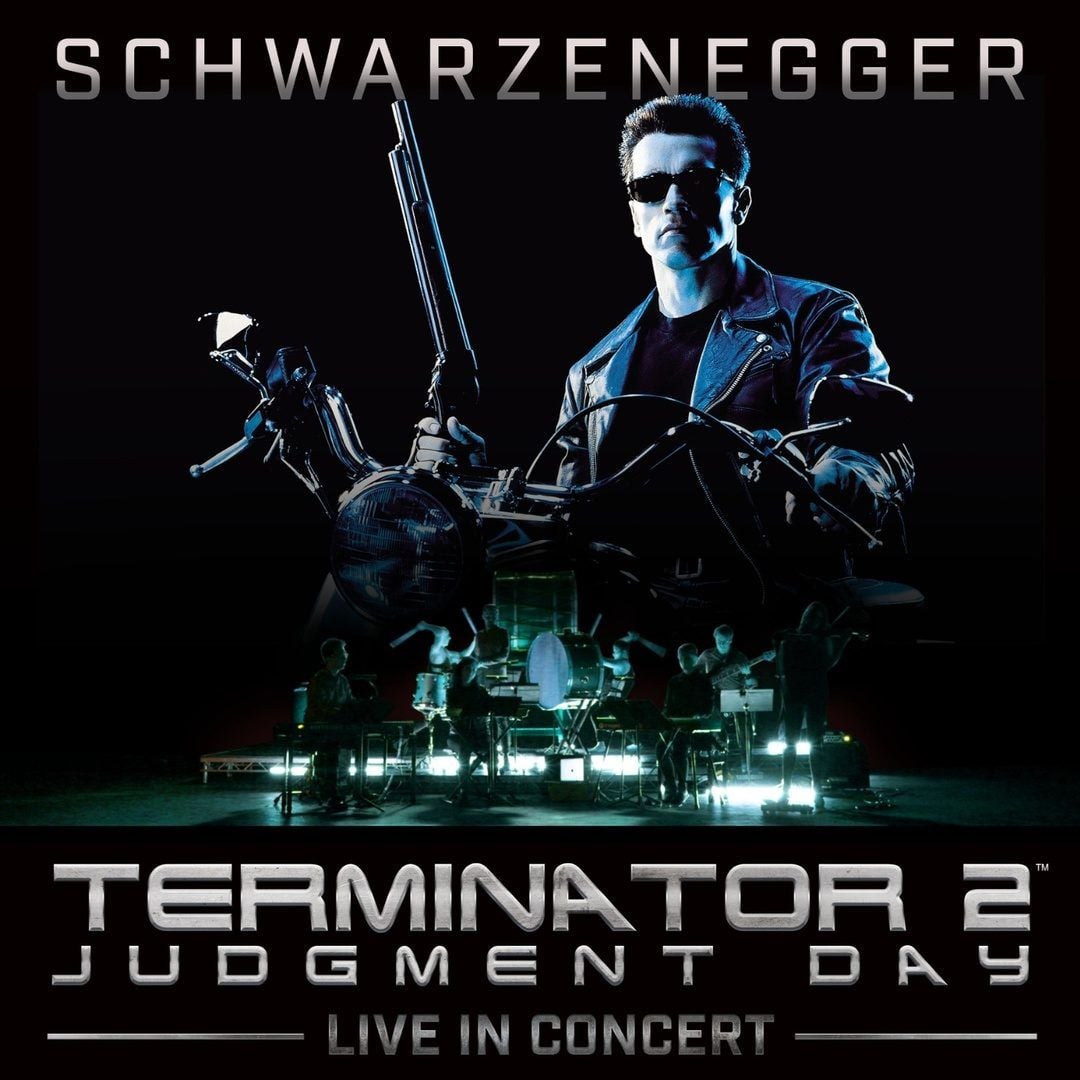 Dark blue-toned poster art of a leather-jacketed man on a motorcycle holding a shotgun, above a small orchestra on a lit stage and the words Terminator 2 Judgment Day Live in Concert