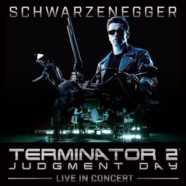 Dark blue-toned poster art of a leather-jacketed man on a motorcycle holding a shotgun, above a small orchestra on a lit stage and the words Terminator 2 Judgment Day Live in Concert