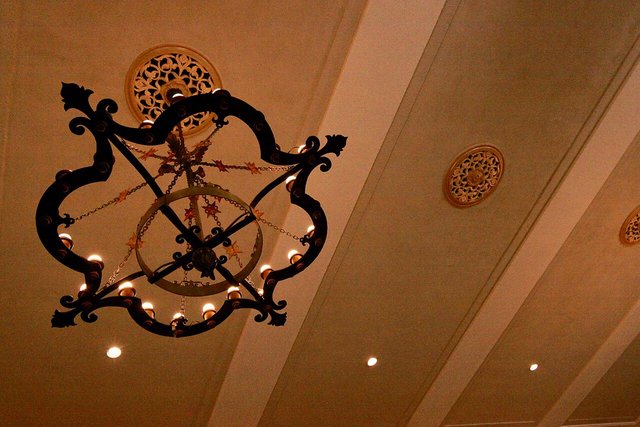 A decorative wrought-iron chandelier on the beamed ceiling of the Ebell of Los Angeles