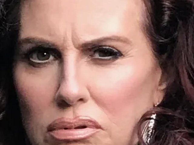 Close-up portrait of Megan Mullally with a skeptical raised eyebrow