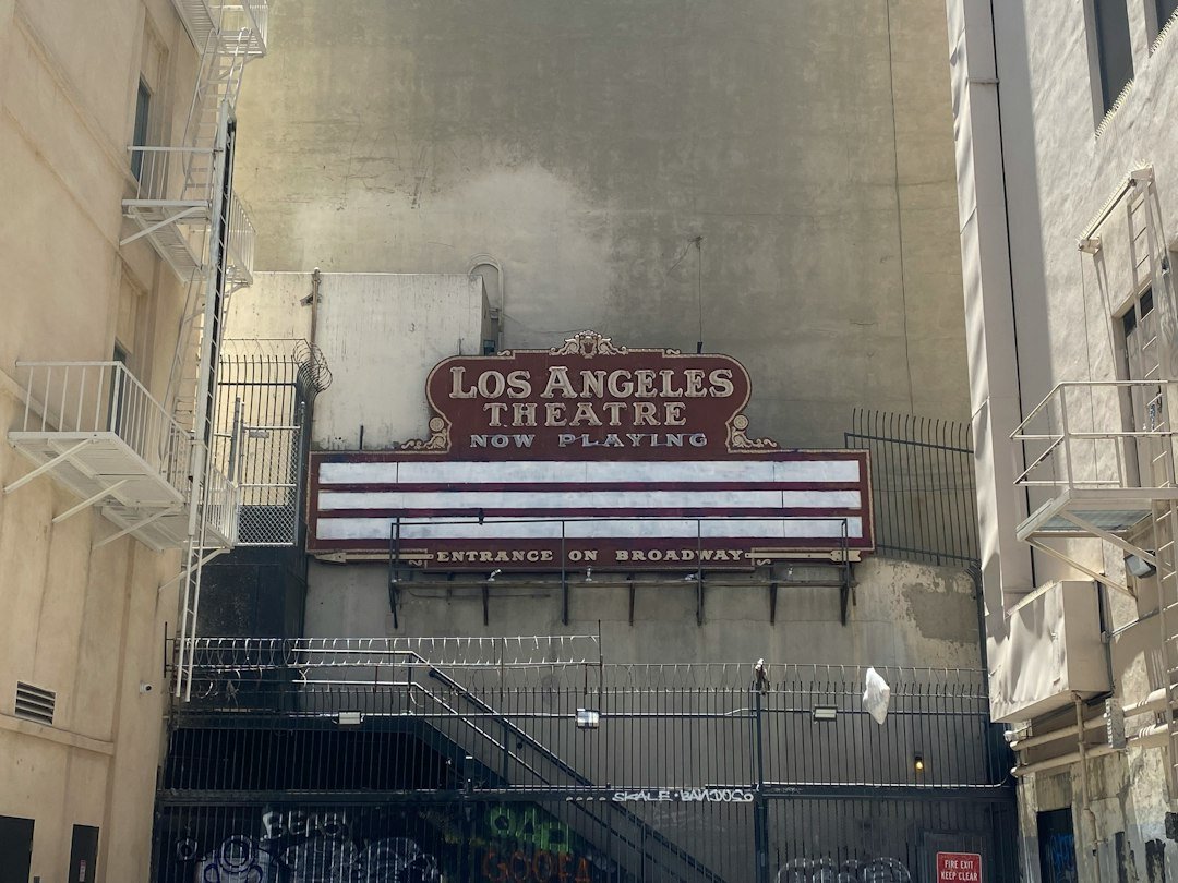 A venue sign glowing on the exterior of a comedy theater at night