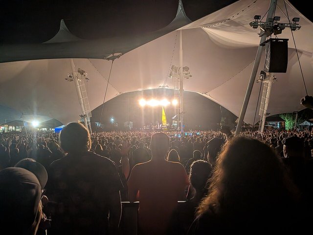 "Weird Al" Yankovic performing on stage, wearing his signature look under concert lighting