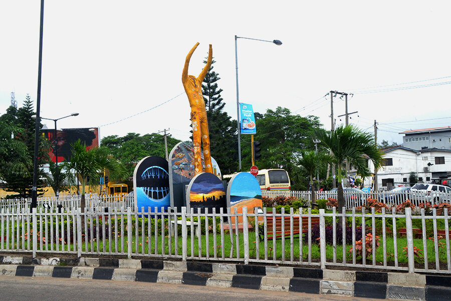Colorful statue of Fela Kuti with raised arms on a traffic roundabout in Lagos, Nigeria