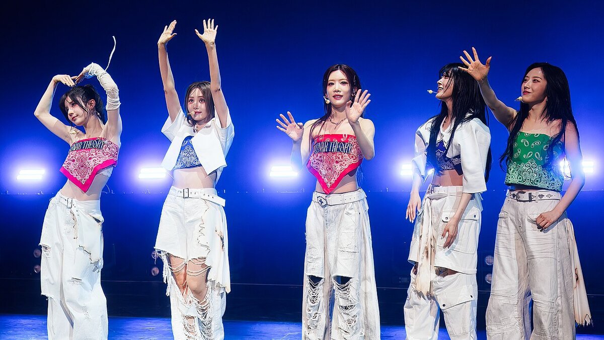 ARTMS members performing on stage in matching dark outfits under stage lighting