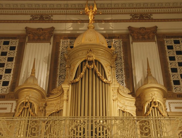A gilded pipe organ facade with ornate carved gold detail