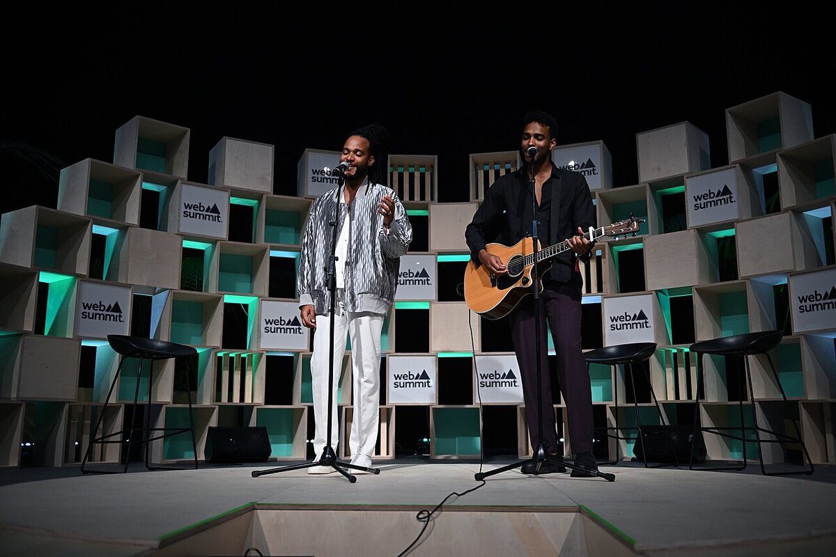 Singer Calema performing on stage next to an acoustic guitarist at Web Summit 2022