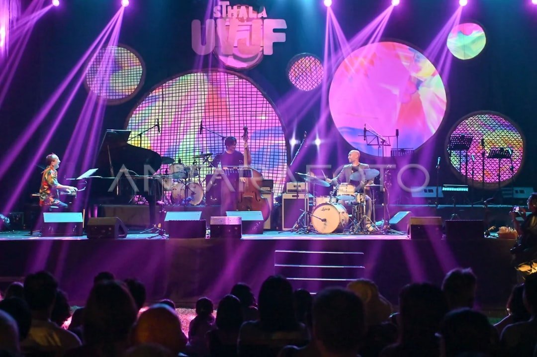 A jazz pianist performing under colorful stage lights at an intimate club venue
