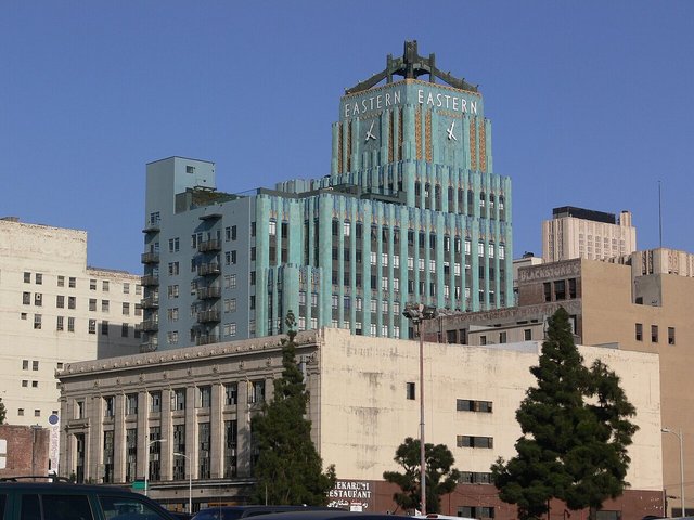 Teal Art Deco Eastern Columbia Building tower rising above Downtown Los Angeles rooftops