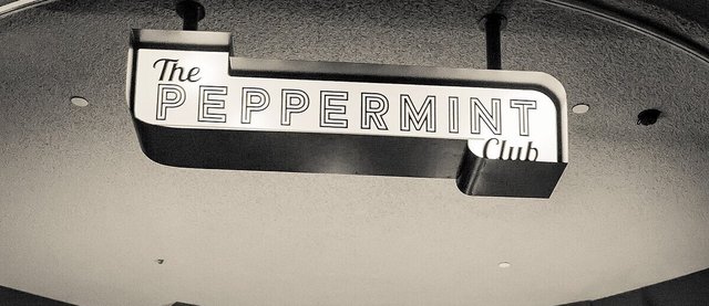 The illuminated Peppermint Club sign hanging over the club's stage