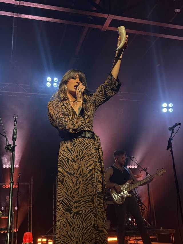 Ella Langley performing on stage with a guitar during a concert