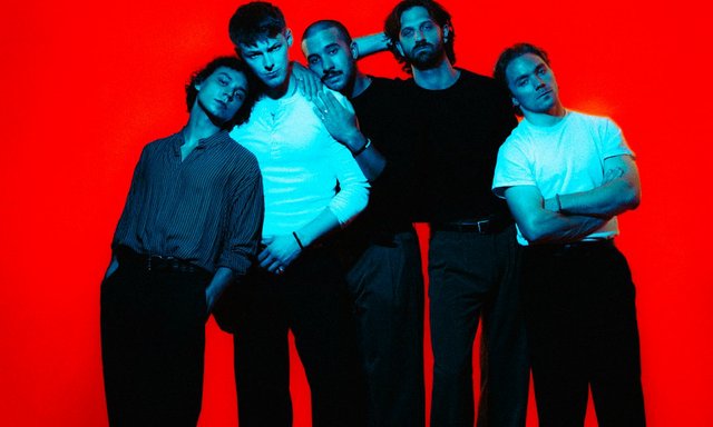 The five members of Friday Pilots Club posed shoulder to shoulder against a bright red backdrop