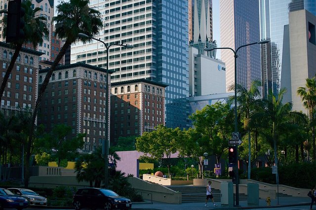 Brick and glass buildings and palm trees around Pershing Square in downtown Los Angeles