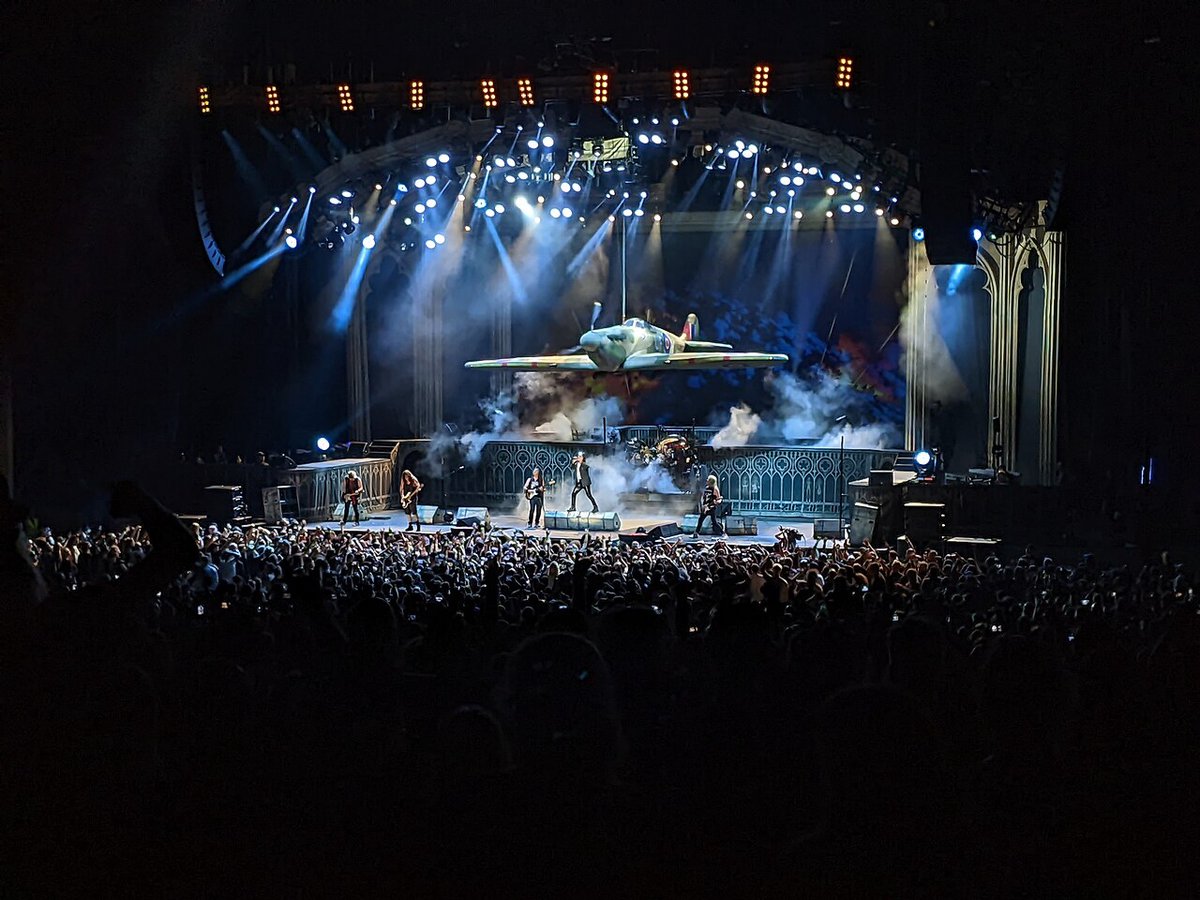 Iron Maiden performing on stage with pyrotechnics at an outdoor amphitheater in Southern California