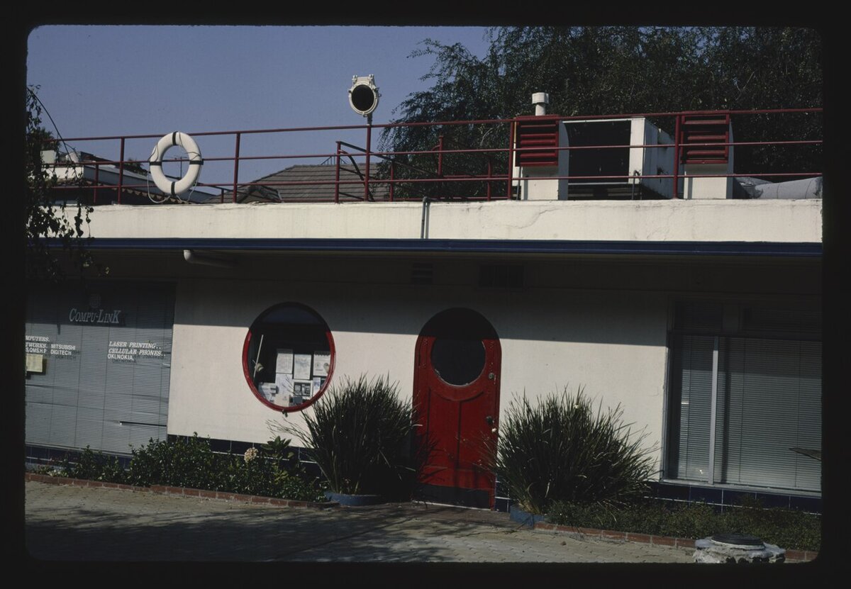 Streamline Moderne building at Crossroads of the World in Hollywood with a life ring, round window and red arched door