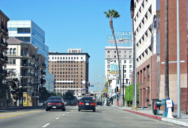 Palm-lined stretch of 7th Street in Westlake, Los Angeles, with mid-rise buildings and traffic