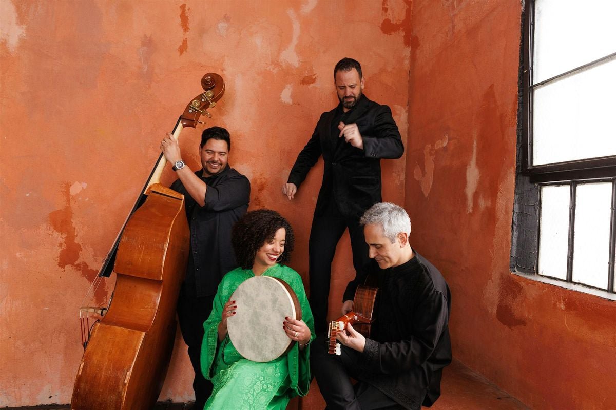 Seffarine's four members against a weathered orange wall: a singer in green holding a frame drum, a guitarist, an upright bassist and a dancer