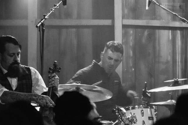 Black-and-white photo of a fiddle player and a drummer from Squirrel Nut Zippers on stage