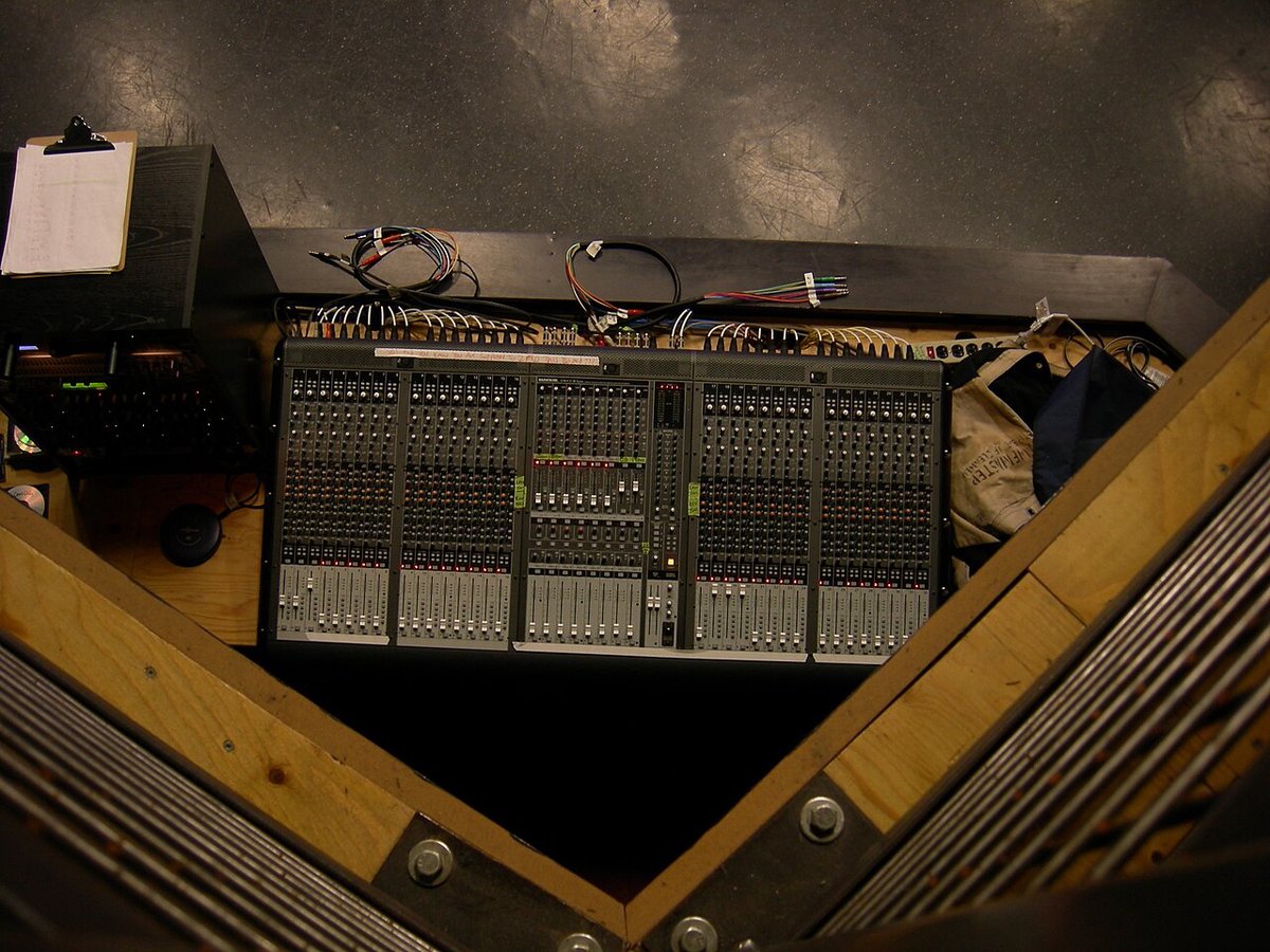 A professional mixing console in a venue's sound booth seen at an angle