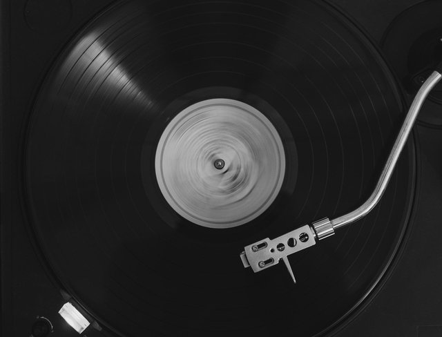 Close-up of a turntable tonearm on a spinning record