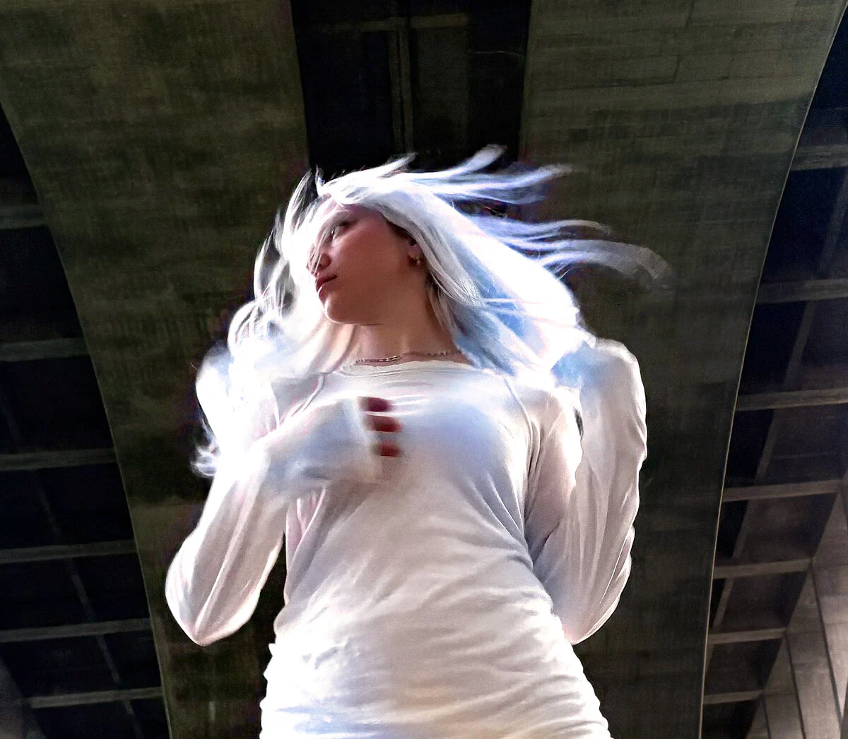 DJ_Dave with long white hair mid-motion under a concrete overpass