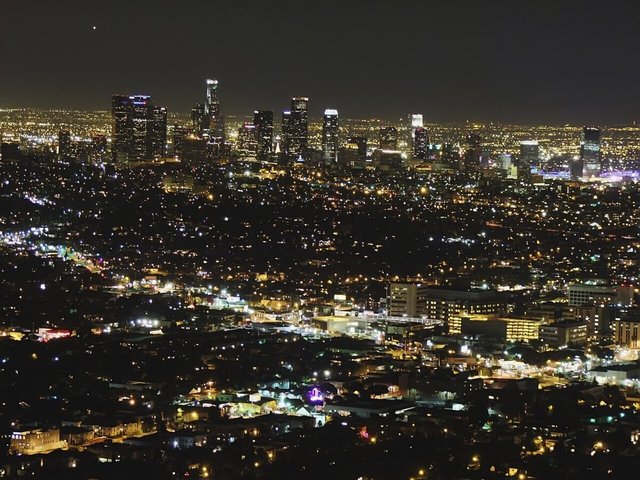 Downtown Los Angeles skyline glowing at night above a sea of city lights