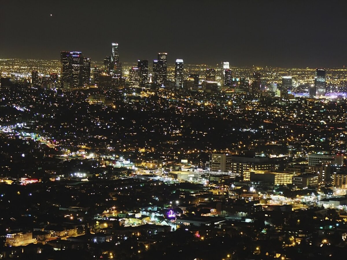 Downtown Los Angeles skyline glowing at night above a sea of city lights