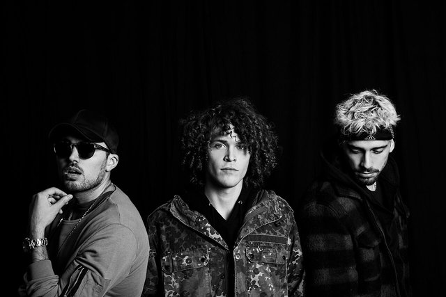 Black and white portrait of the three members of Cheat Codes standing against a dark backdrop