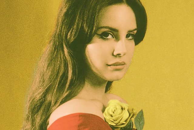Lana Del Rey in a red off-shoulder top holding a yellow rose against a mustard-yellow backdrop