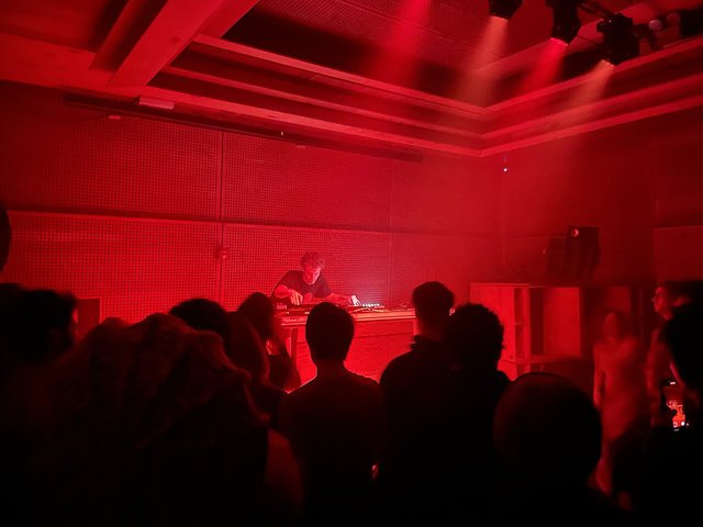 Photay performing a live electronic set behind a table of synths and mixers