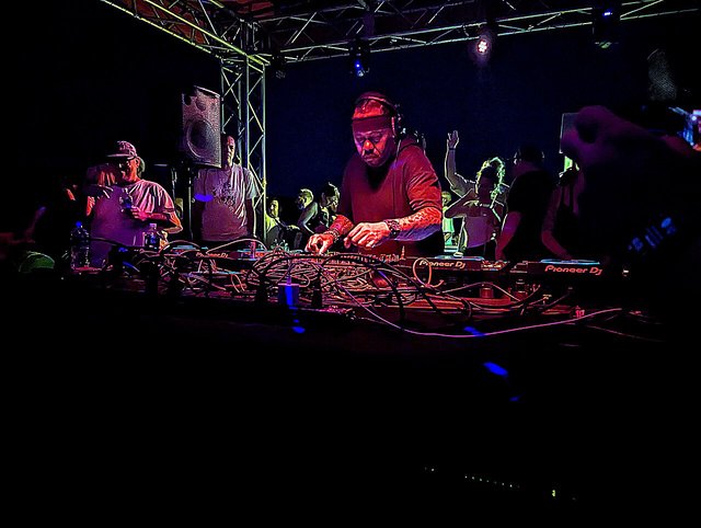 Derrick Carter playing a DJ set behind the decks at an outdoor boat party
