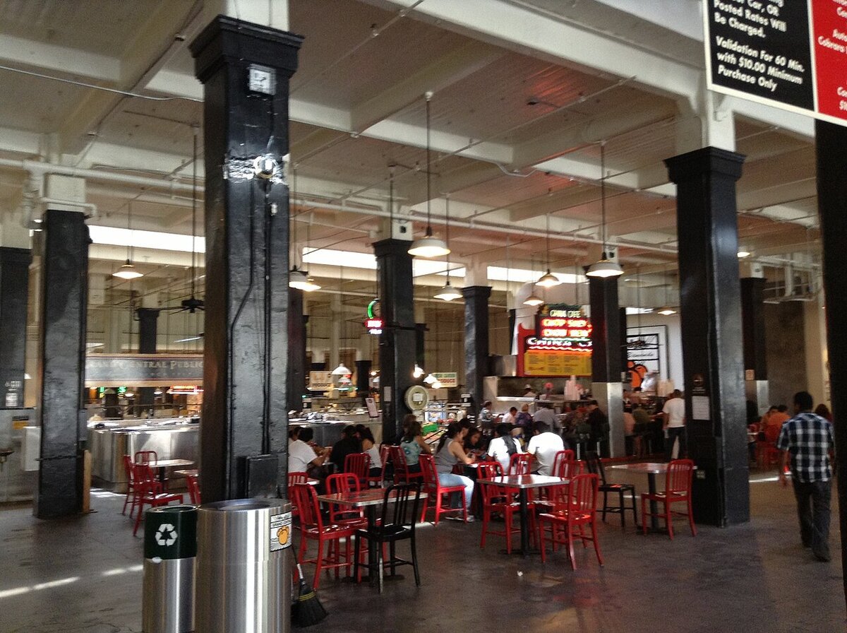 Diners at red tables inside the Grand Central Market food hall in downtown Los Angeles