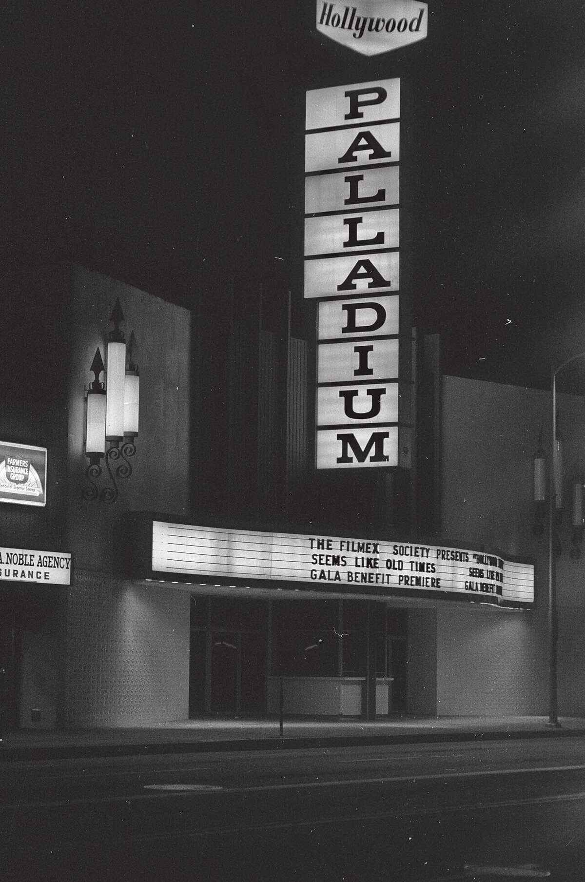 Black-and-white night photo of the vertical Palladium sign and lit marquee on Sunset Boulevard in Hollywood