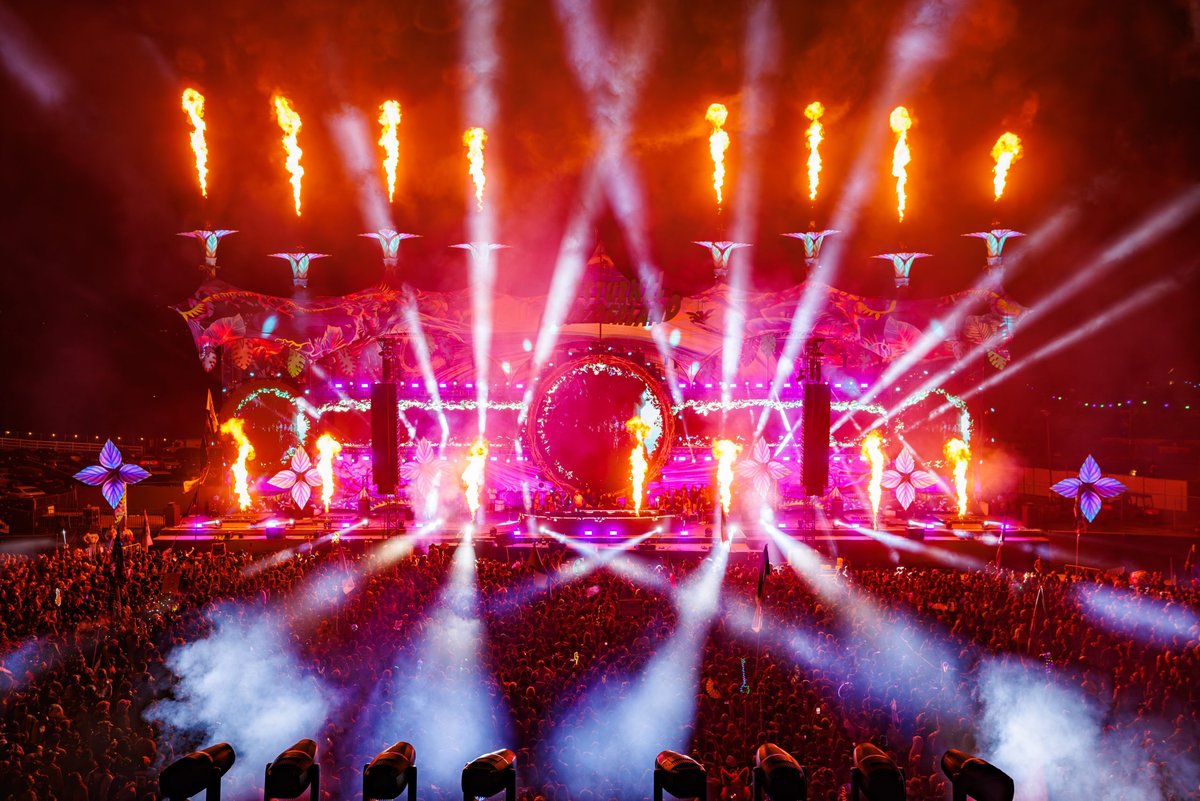 Nocturnal Wonderland main stage at night with flame jets, pink lasers and a packed crowd in fog