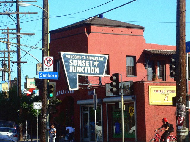 Welcome to Silverlake Sunset Junction sign mounted on a red corner building near El Cid on Sunset Boulevard