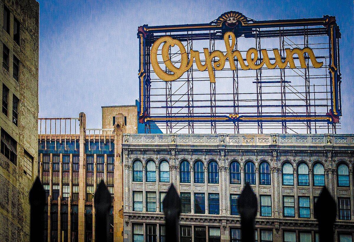 Yellow Orpheum rooftop sign above ornate old buildings on Broadway in downtown Los Angeles