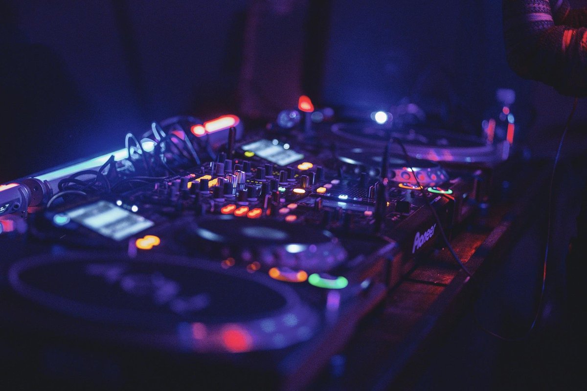Vinyl decks glowing in dim techno club lighting