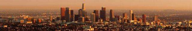 Downtown Los Angeles skyline glowing in orange light at sunset