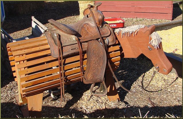 A wooden horse play structure at a fall farm