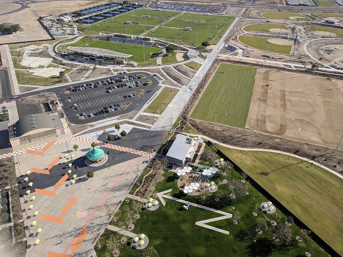Aerial view of the Great Park in Irvine with a teal carousel, sports fields and a landscaped lawn