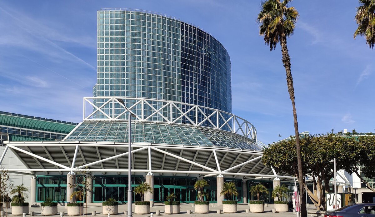 Glass tower and canopy entrance of the Los Angeles Convention Center under a blue sky