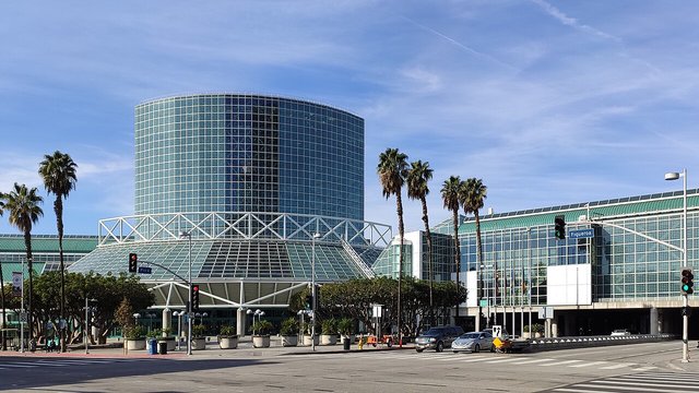 Glass drum tower and rotunda of the Los Angeles Convention Center at Pico and Figueroa under a blue sky